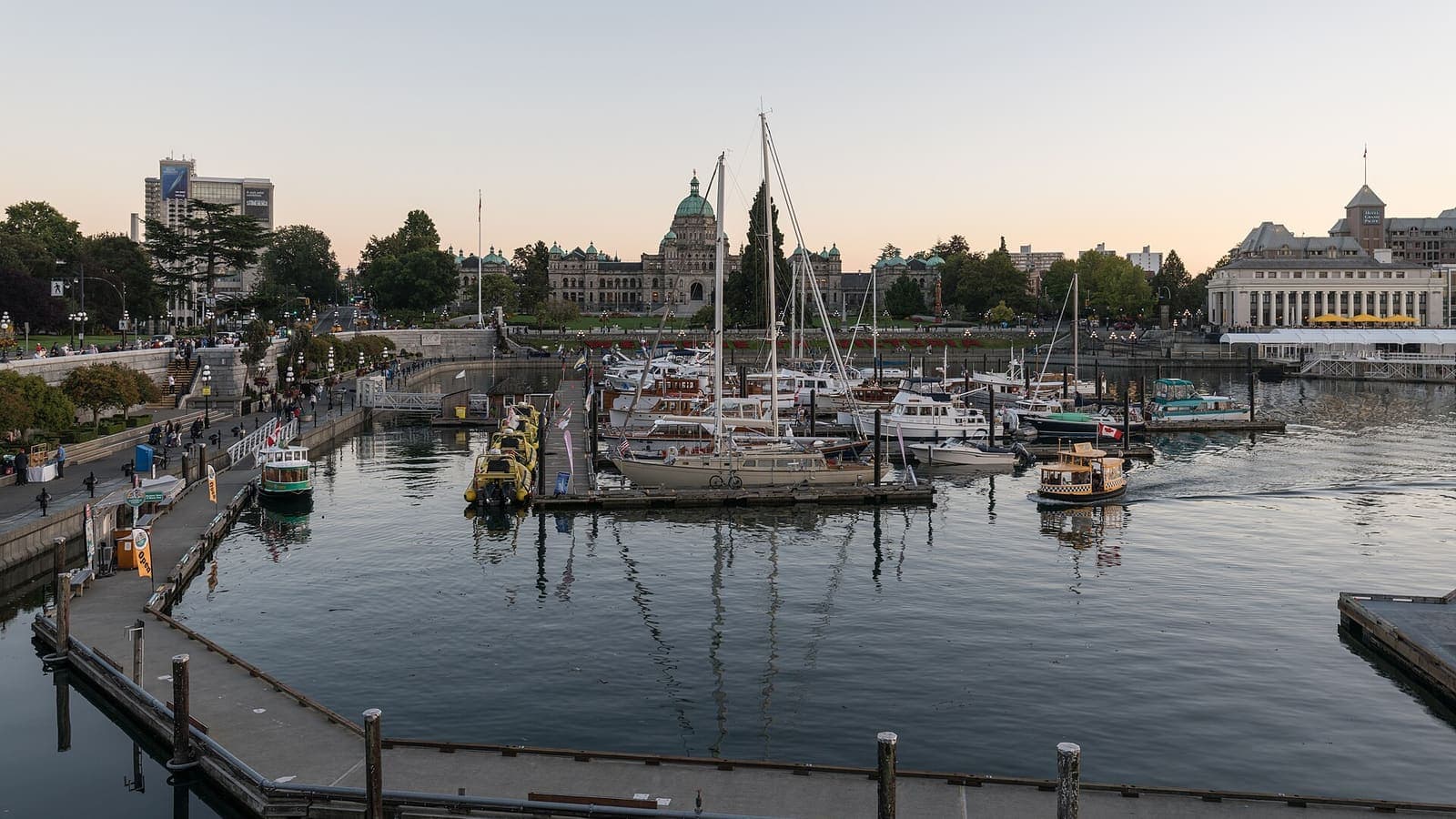 Boats in Victoria's Inner Harbour at dusk, with the Parliament Buildings behind, British Columbia